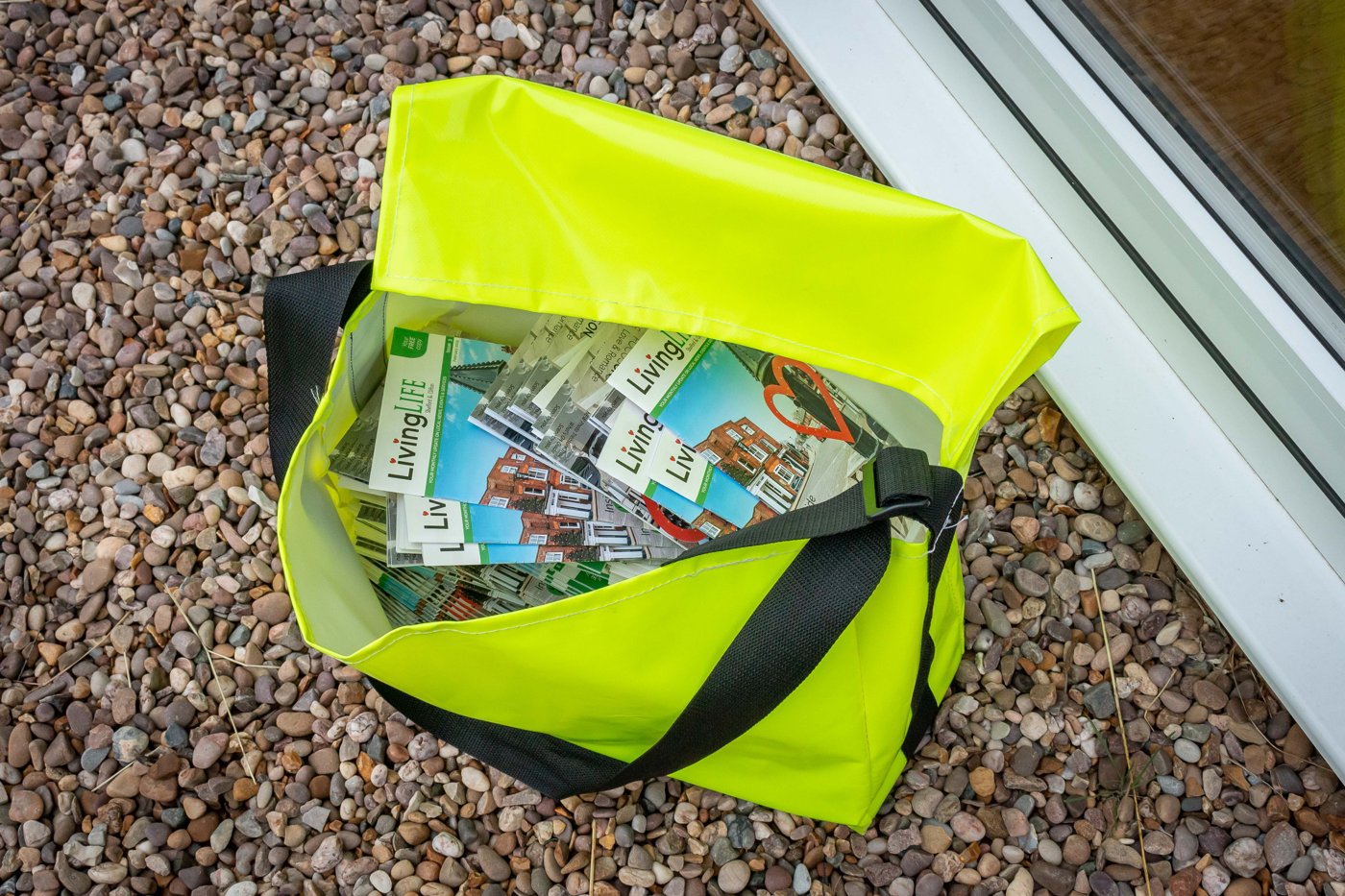 LivingLife magazines in a distributor’s delivery bag outside a local home